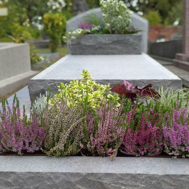 Pierre tombale en pierre bleue avec des fleurs